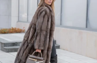 Женщина в длинной роскошной меховой шубе идет по городской улице,